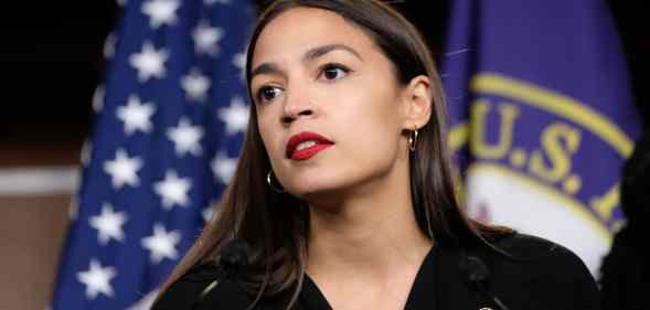 Alexandria Ocasio-Cortez in front of a US flag