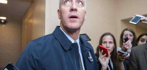 Sean Patrick Maloney looks upwards as he speaks to reporters, their arms raised while holding mobile phones