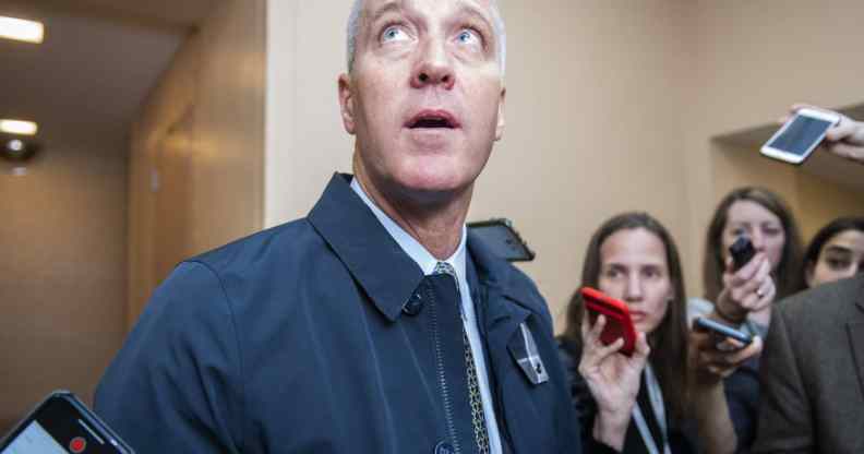 Sean Patrick Maloney looks upwards as he speaks to reporters, their arms raised while holding mobile phones