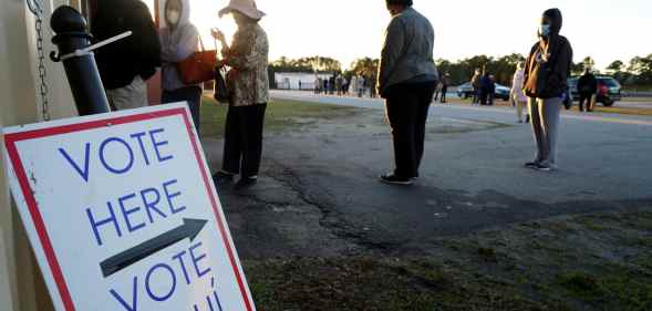 Voters stand in line to cast their ballots during the first day of early voting in the US Senate Georgia run-off elections