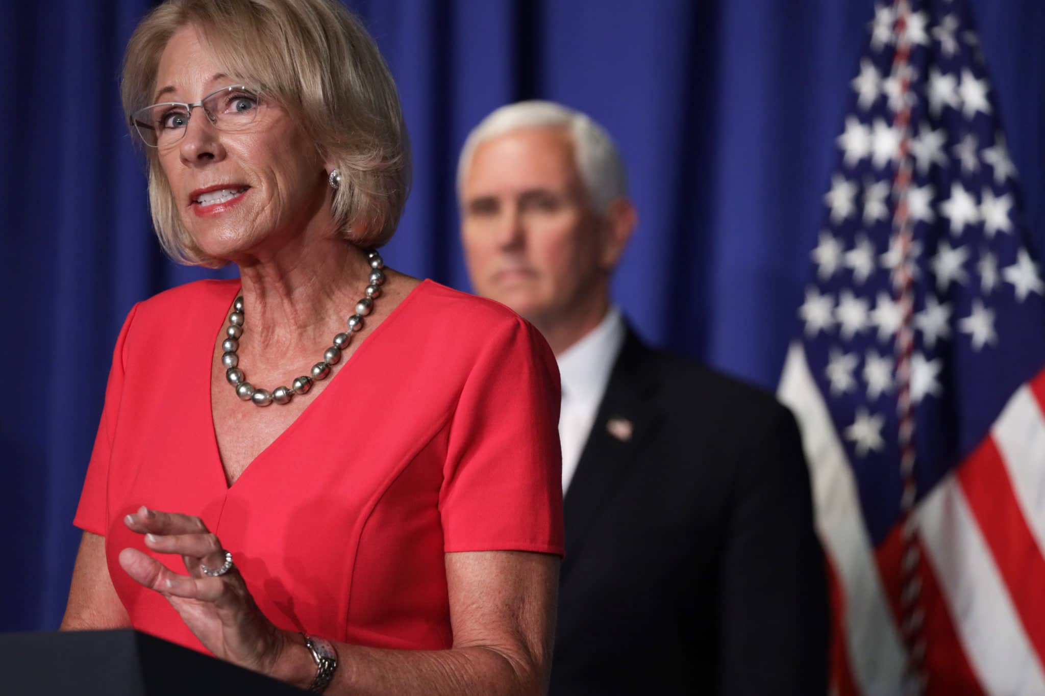 US Secretary of Education Betsy DeVos speaks as vice president Mike Pence looks on