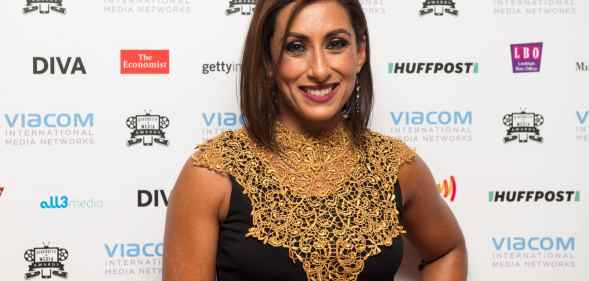 Saira Khan poses in a gold and black dress