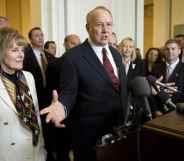 James Dobson in a red tie and black suit standing by his wife Shirley Dobson (L)