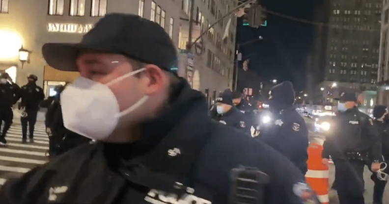 NYPD officers outside Trump Tower. One is close to the camera wearing a face mask