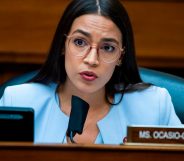 Alexandria Ocasio-Cortez in a blue suit speaking into a microphone in congress