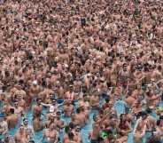 Dozens of men in a pool at a circuit party