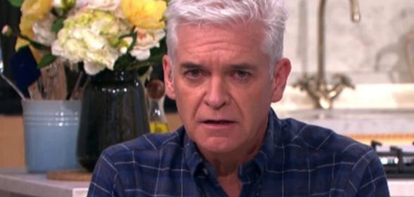 Philip Schofield looks unsettled at the camera while wearing a dark print shirt