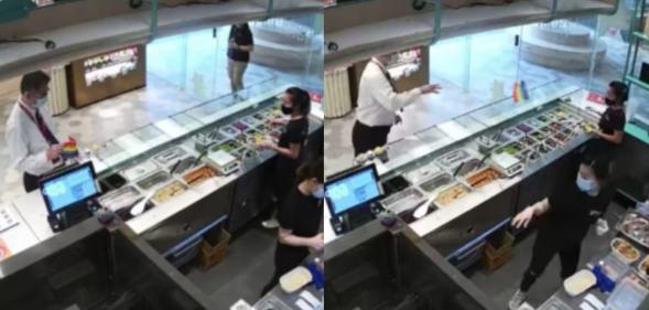 A man in a white shirt and tie grabs and throws an LGBT+ Pride flag at staff behind the counter of a food stall