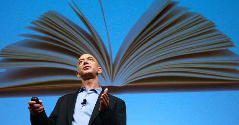 Amazon founder Jeffrey Bezos speaks in front of an image of an opened book