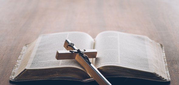 Picture of a bible with a cross lying on it