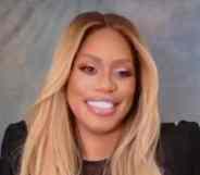 Laverne Cox smiles to the camera in a black top