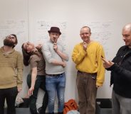 Five people standing in front of a whiteboard