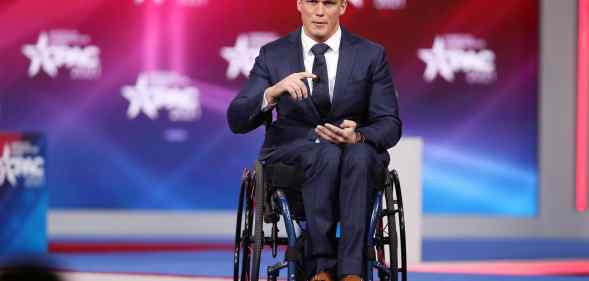 Madison Cawthorn gestures in a suit as he addresses the Conservative Political Action Conference