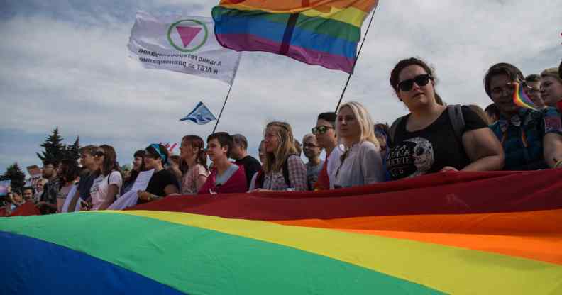 Members of the Alliance of Heterosexuals and LGBT for Equality, their flag on the left, at the St Petersburg LGBT+ Pride