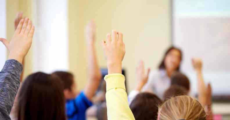 Children raising hands in classroom