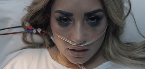 Demi Lovato sings from a hospital bed in her new "Dancing With The Devil" music video