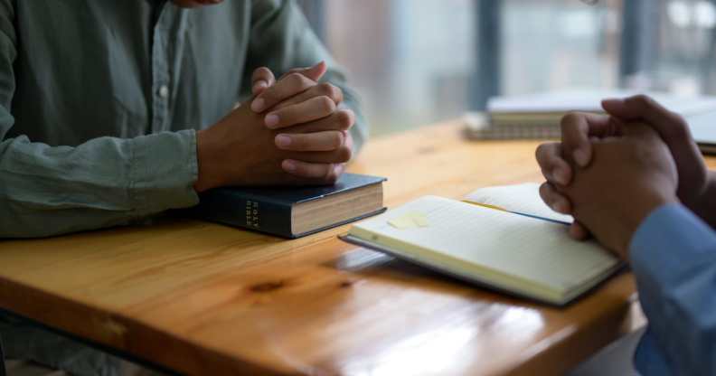 Two people pray with Bibles