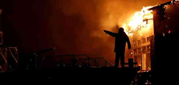 House building on fire at night