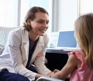 A paediatrician sits with a patient.