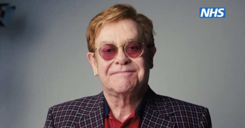 Elton John smiles against a grey background