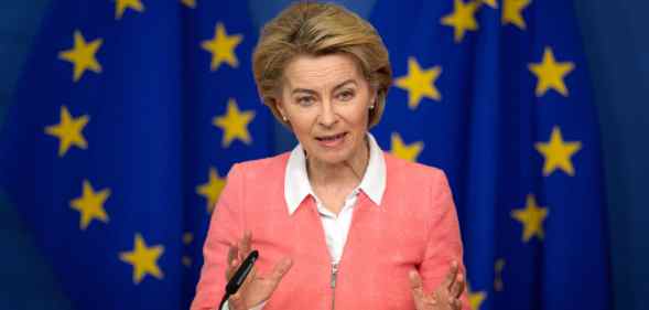 President of the European Commission Ursula von der Leyen holds a press conference in a pink zip-up jacket agains the EU flag