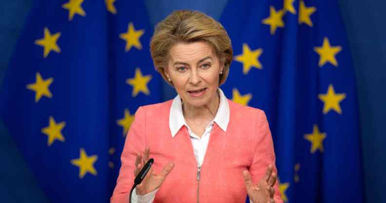 President of the European Commission Ursula von der Leyen holds a press conference in a pink zip-up jacket agains the EU flag