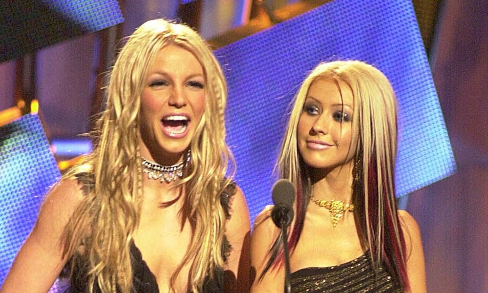 Britney Spears laughs as Christina Aguilera looks on at the MTV VMAs