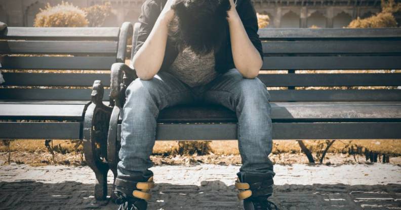 sad man by himself outside on park bench