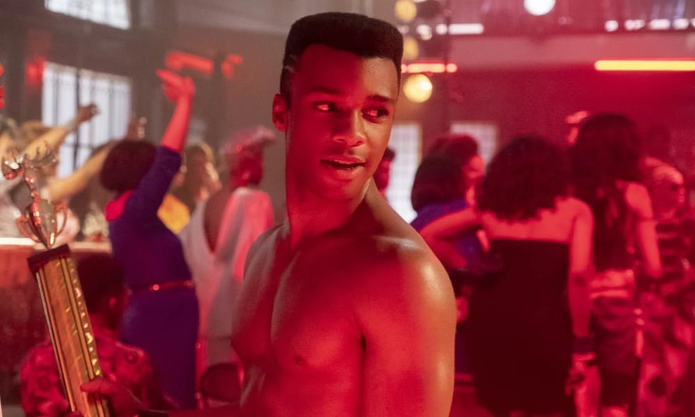 Dyllón Burnside as Ricky in Pose, topless, holding a trophy