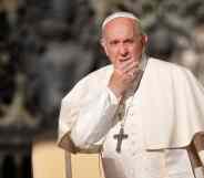 Pope Francis looks on with his hand over his face