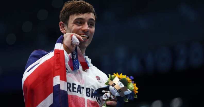 Tom Daley posing with his gold medal