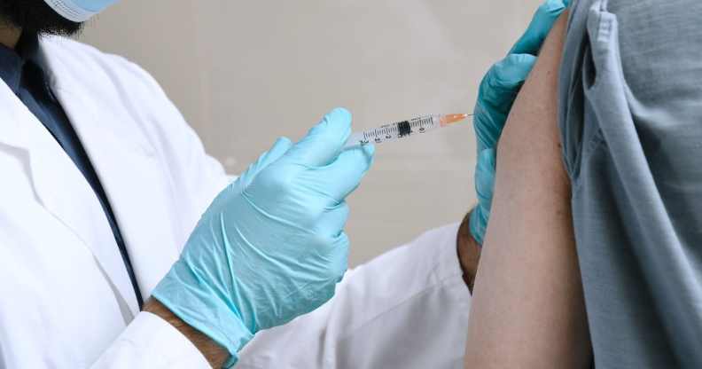 A doctor injects a person with a vaccine