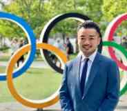 Trans activist and former fencer Fumino Sugiyama smiling in front of olympic rings