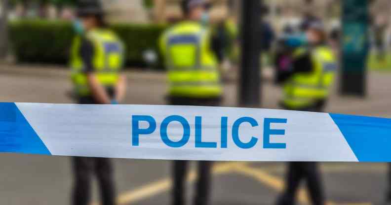 Police officers stand behind a police line