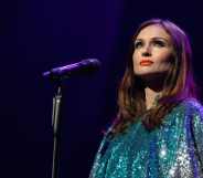 Sophie Ellis-Bextor performs in a teal dress standing behind a microphone