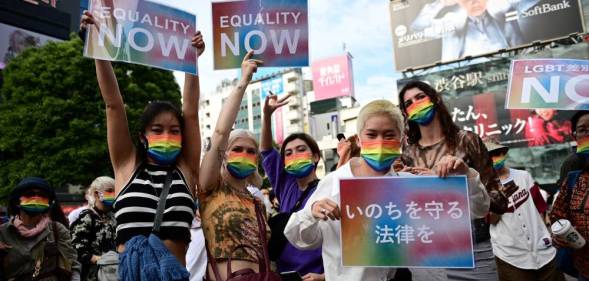 Demonstrators hold up signs in support of LGBT+ legislation in the Shibuya district of Tokyo, Japan