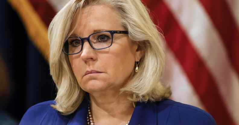 Liz Cheney in a blue jacket against the US flag