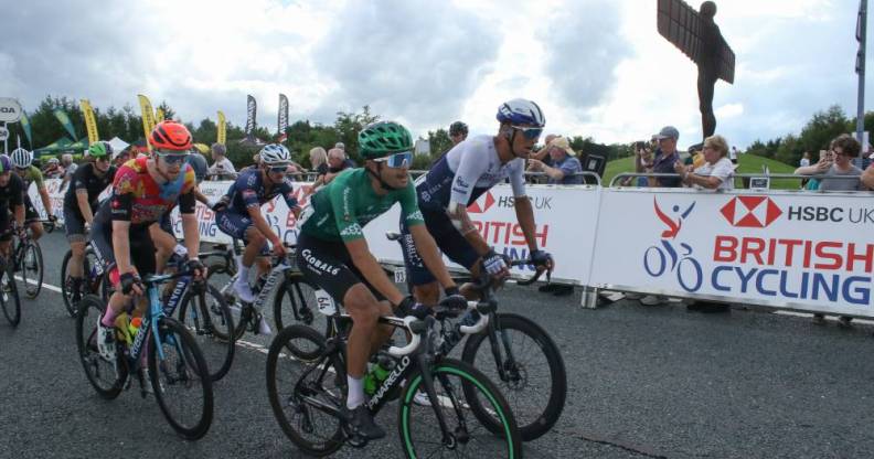 Cyclists seen in front of a sign for British Cycling, the boss of the governing body has recently condemned homophobia and transphobia in the sport