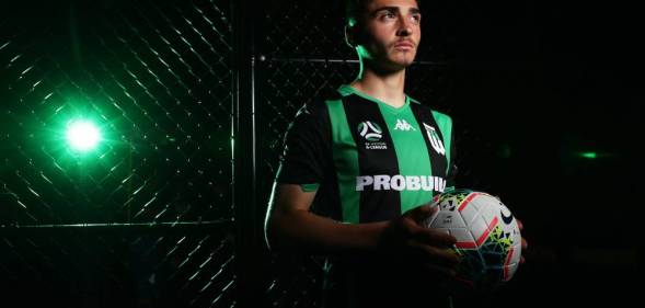 a picture of josh cavallo in a green uniform holding a white football