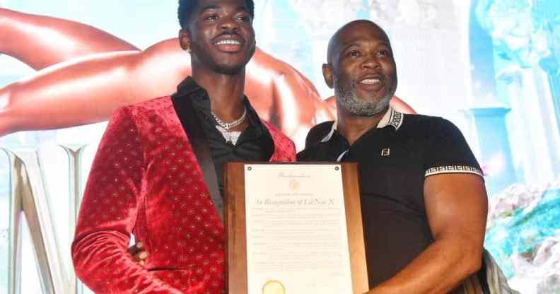 A picture of Lil Nas X and his father Robert Stafford holding up a plaque at a homecoming event for the rapper in Atlanta Georgia