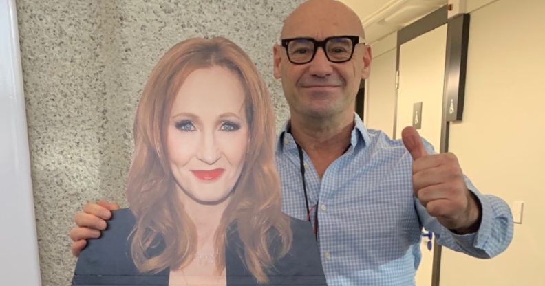 A bald man stands next to a cardboard cutout of JK Rowling