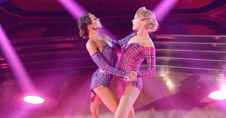 A still image of JoJo Siwa and Jenna Johnson from Dancing With the Stars where they dance amid pink and blue lighting