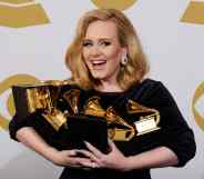 Adele holding an armful of Grammys