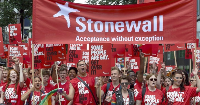 Protesters holding placards saying 'some poeple are gay/bi/trans, get over it'