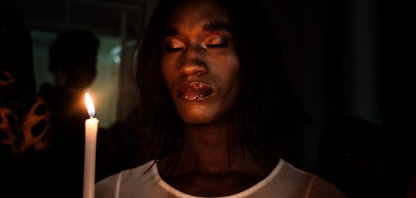 A member of the trans community holds candles during the vigil of the Transgender day of Remembrance