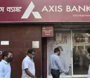 People walk past an Axis Bank in Kolkata, India