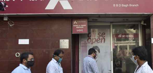 People walk past an Axis Bank in Kolkata, India