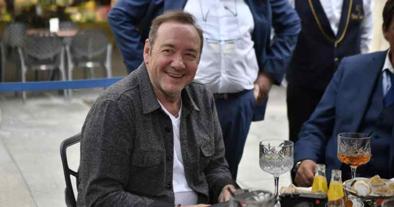 Kevin Spacey is seen sitting outside a cafe