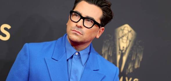 Dan Levy is seen wearing a light blue collared shirt with a slightly darker blue jacket at the 73rd Primetime Emmy Awards in September