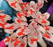 University students display red ribbons during an event to promote the awareness of AIDS at the Sichuan University on World AIDS Day 2009.